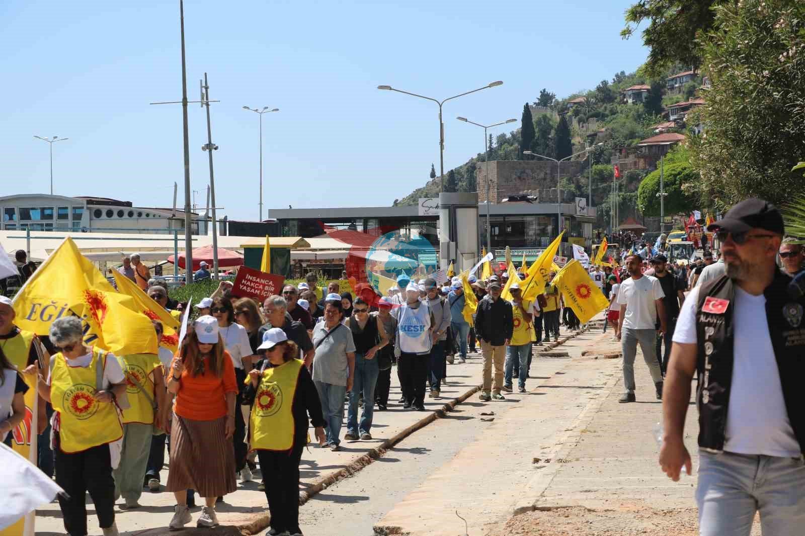 1 Mayıs kutlamalarında yürüyen işçilerle çalışan işçiler aynı karede