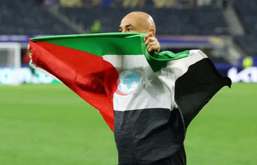 Misr terma jamoasi bosh murabbiyi Xosam Hassan Avstraliyaga qarshi o'yindan so'ng Falastin bayrog'ini ko'targan payt